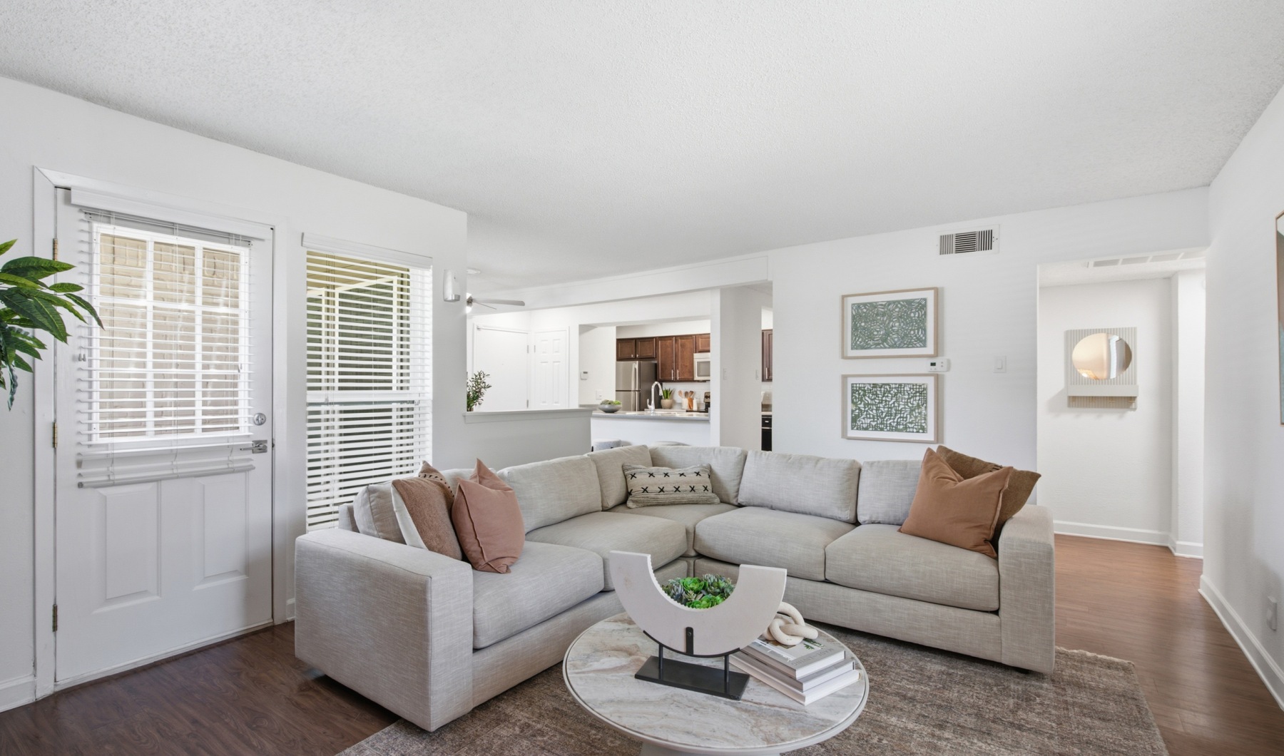 Bright open-concept living room with light wood-style flooring, white walls, and modern decor at Communities of Bent Tree