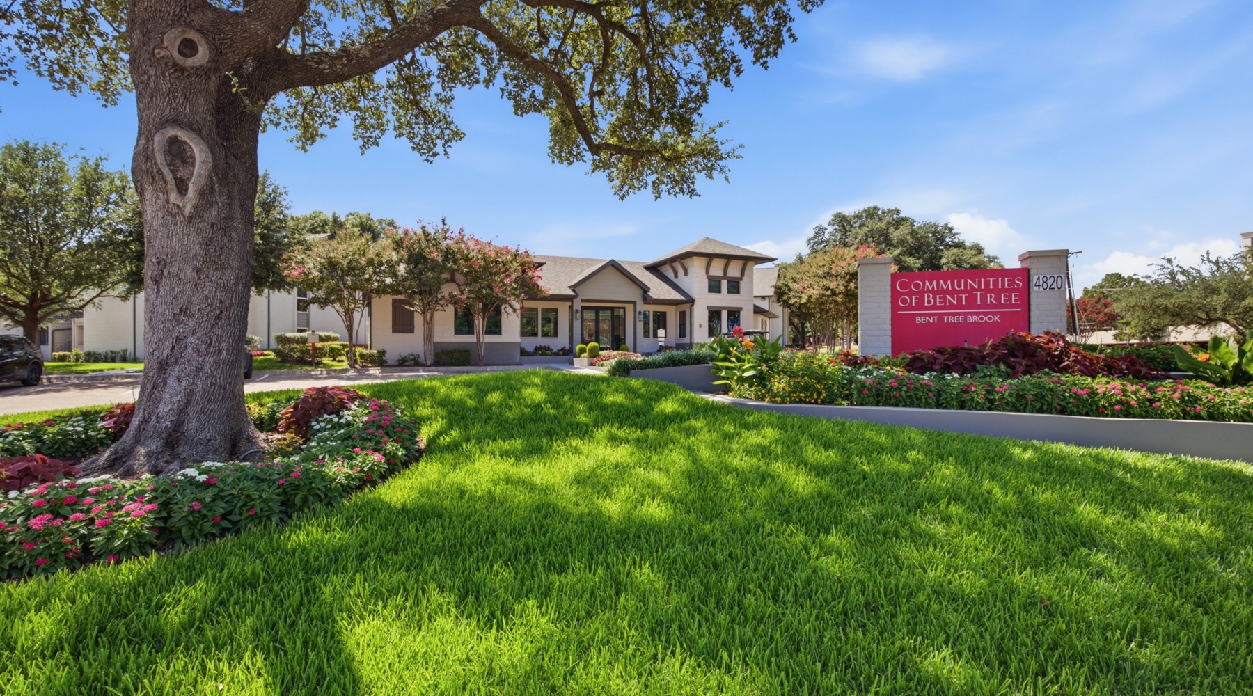 Exterior view of Communities of Bent Tree clubhouse entrance and leasing office with manicured landscaping