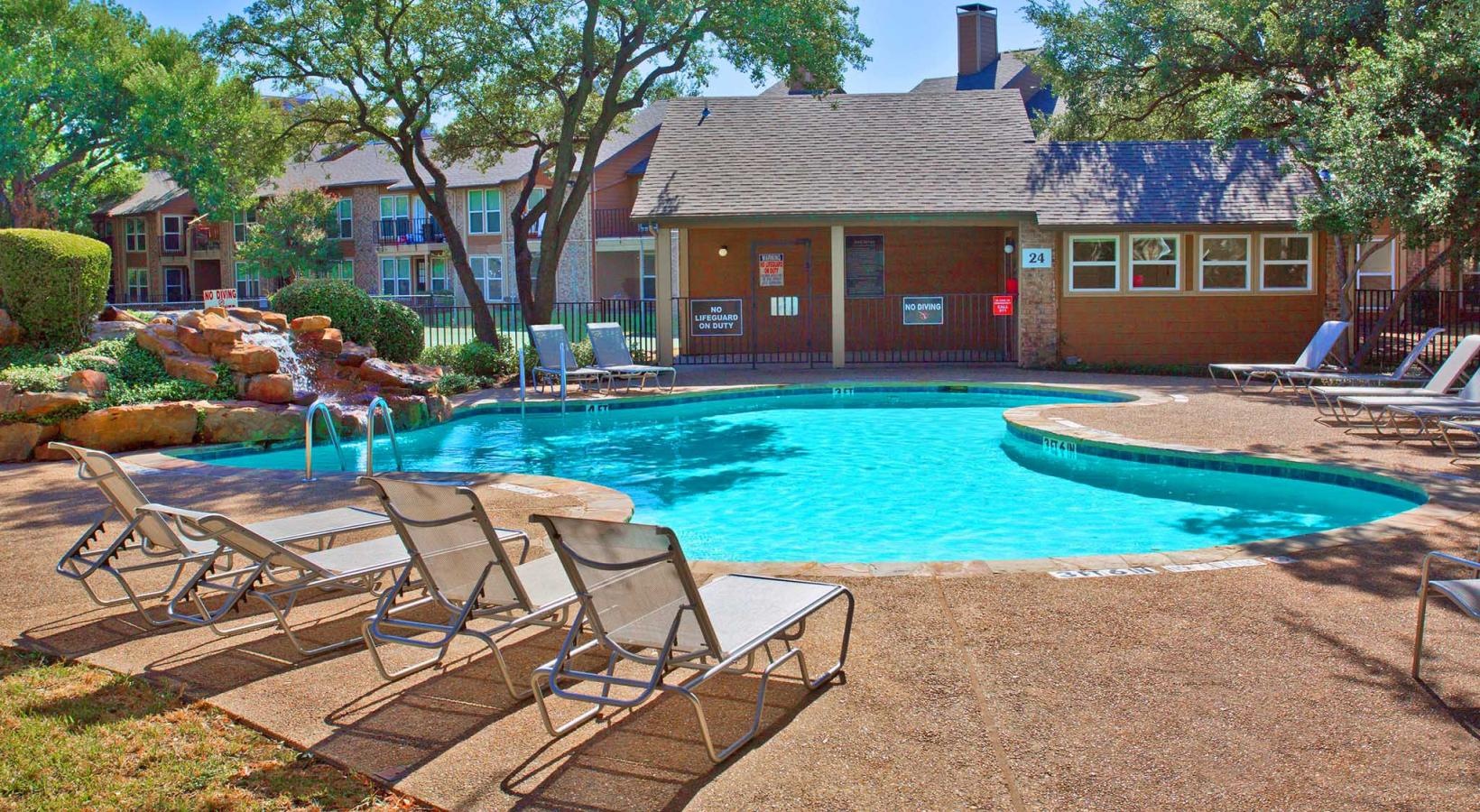 Relax and unwind poolside a swimming pool with chairs around it
