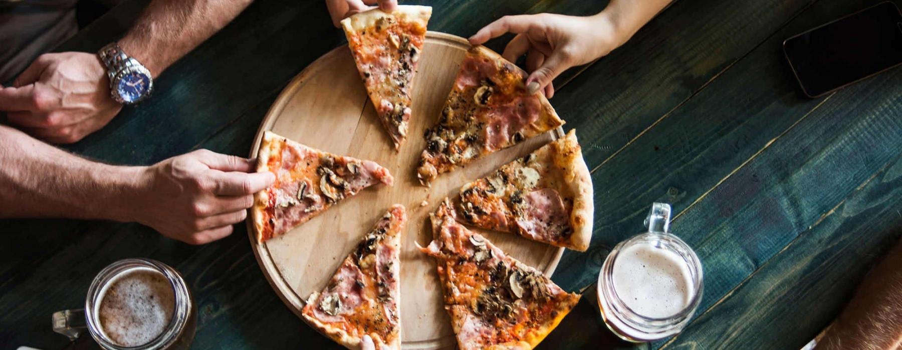 a group of people eating pizza