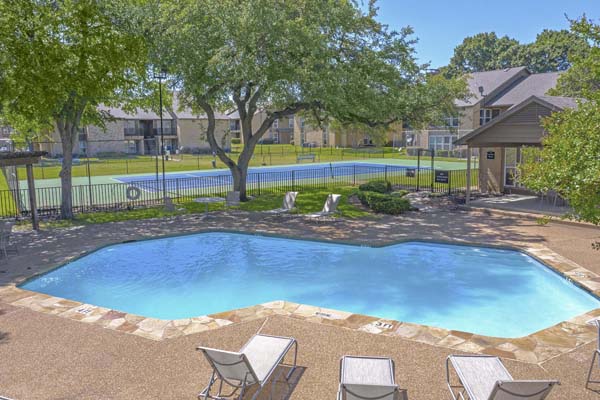 One of seven pools in the apartment community located next to one of several tennis courts.