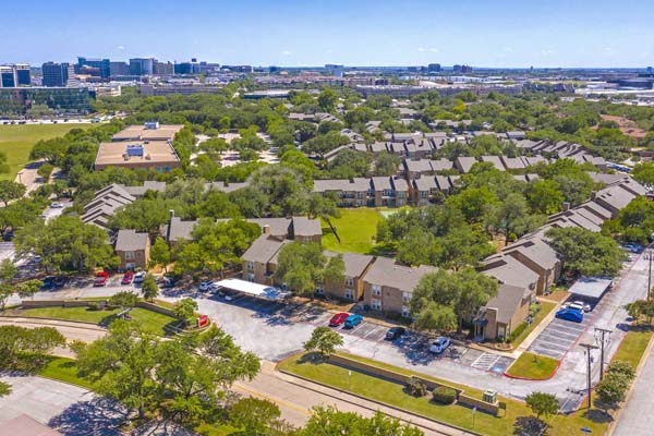 Drone shot of the South East side of the apartment community, Bent Tree Fountains. You can also see the pet playground and tennis courts in the center of all the buildings.